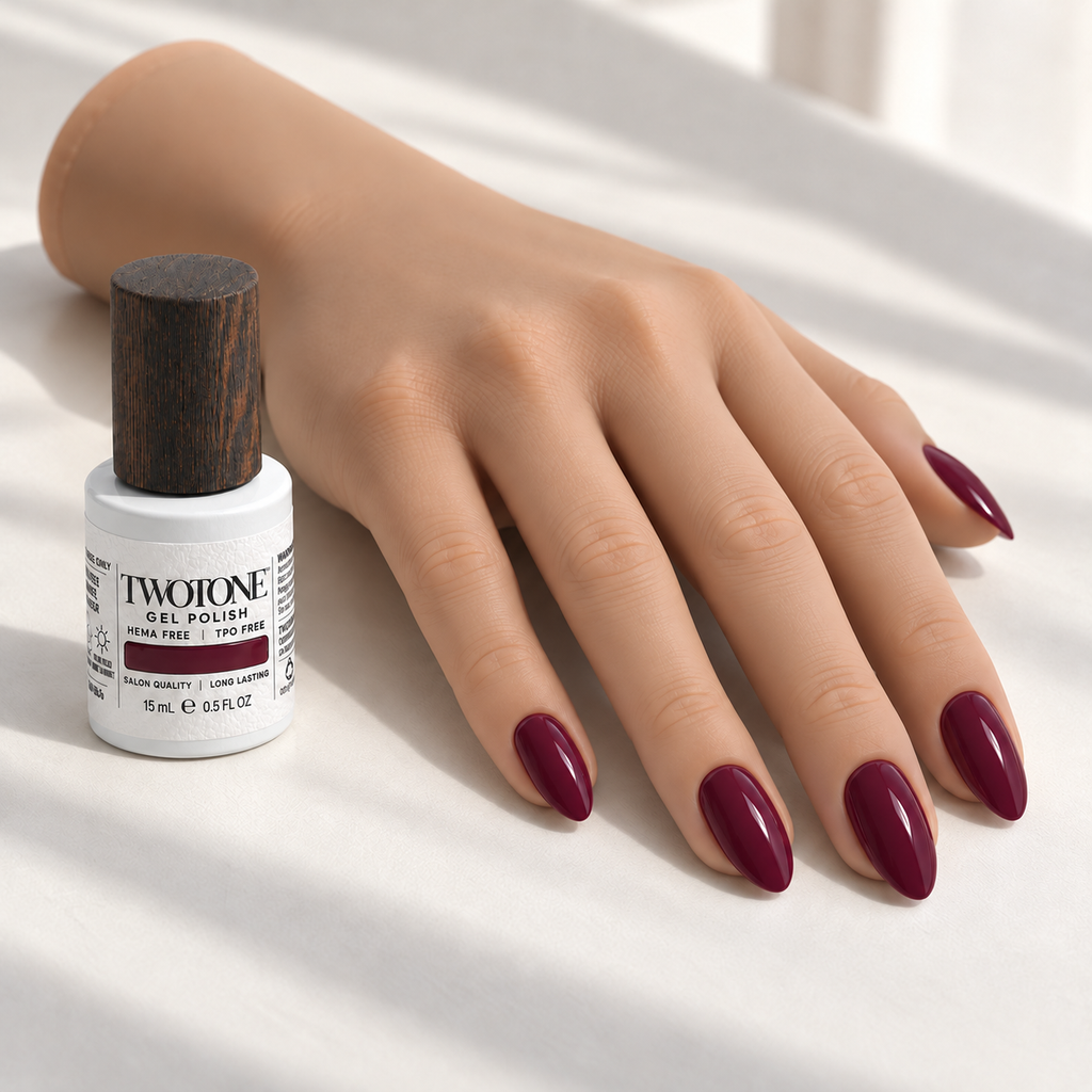 Illustrative Deep Plum manicure on a silicone practice hand beside the TWOTONE bottle; color appearance may vary
