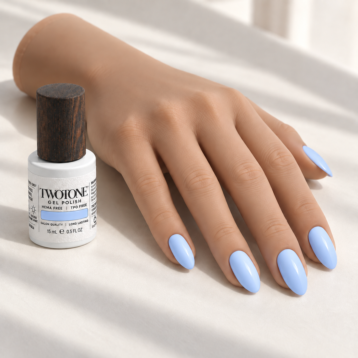Illustrative Periwinkle Wash manicure on a silicone practice hand beside the TWOTONE bottle; color appearance may vary