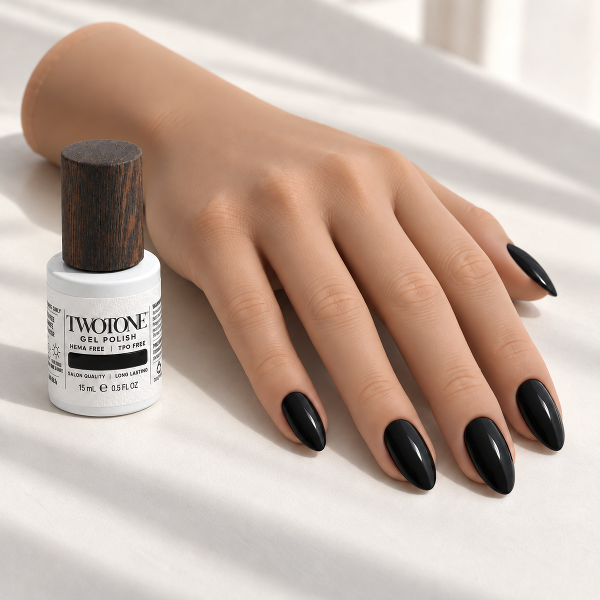 Illustrative Pure Noir manicure on a silicone practice hand beside the TWOTONE bottle; color appearance may vary