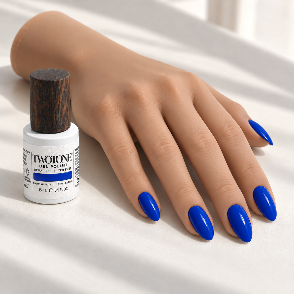Illustrative Royal Abyss manicure on a silicone practice hand beside the TWOTONE bottle; color appearance may vary